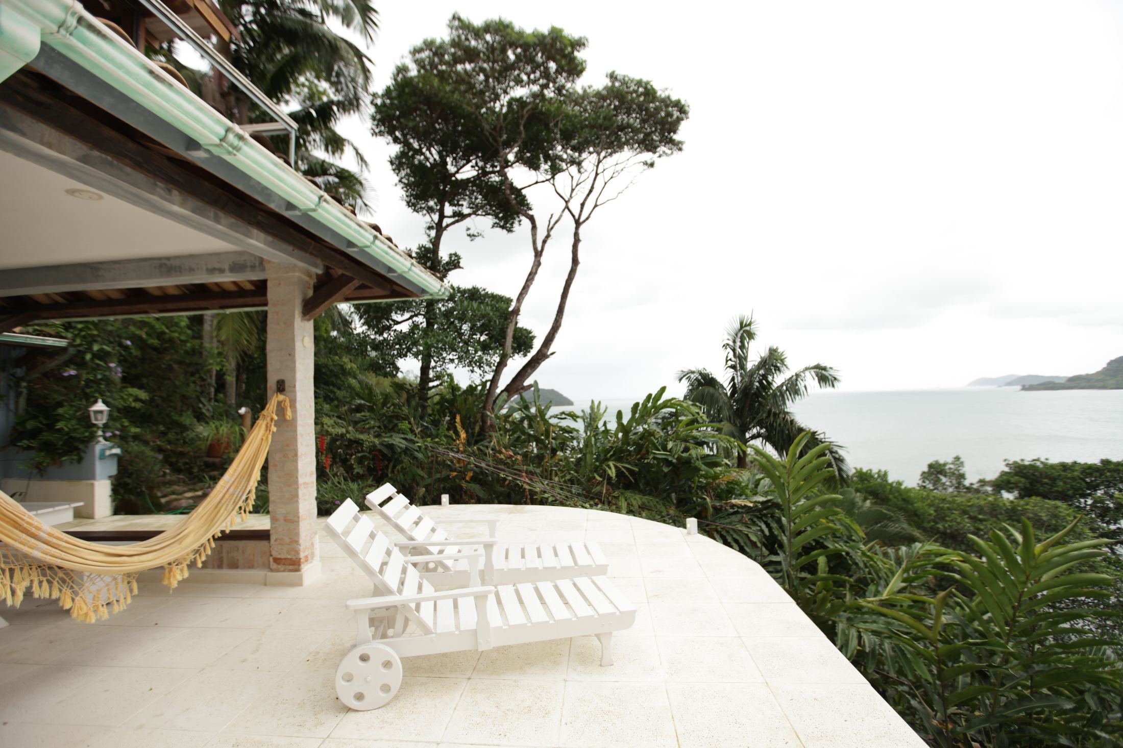 The white terrace with hammock and loungers above the sea